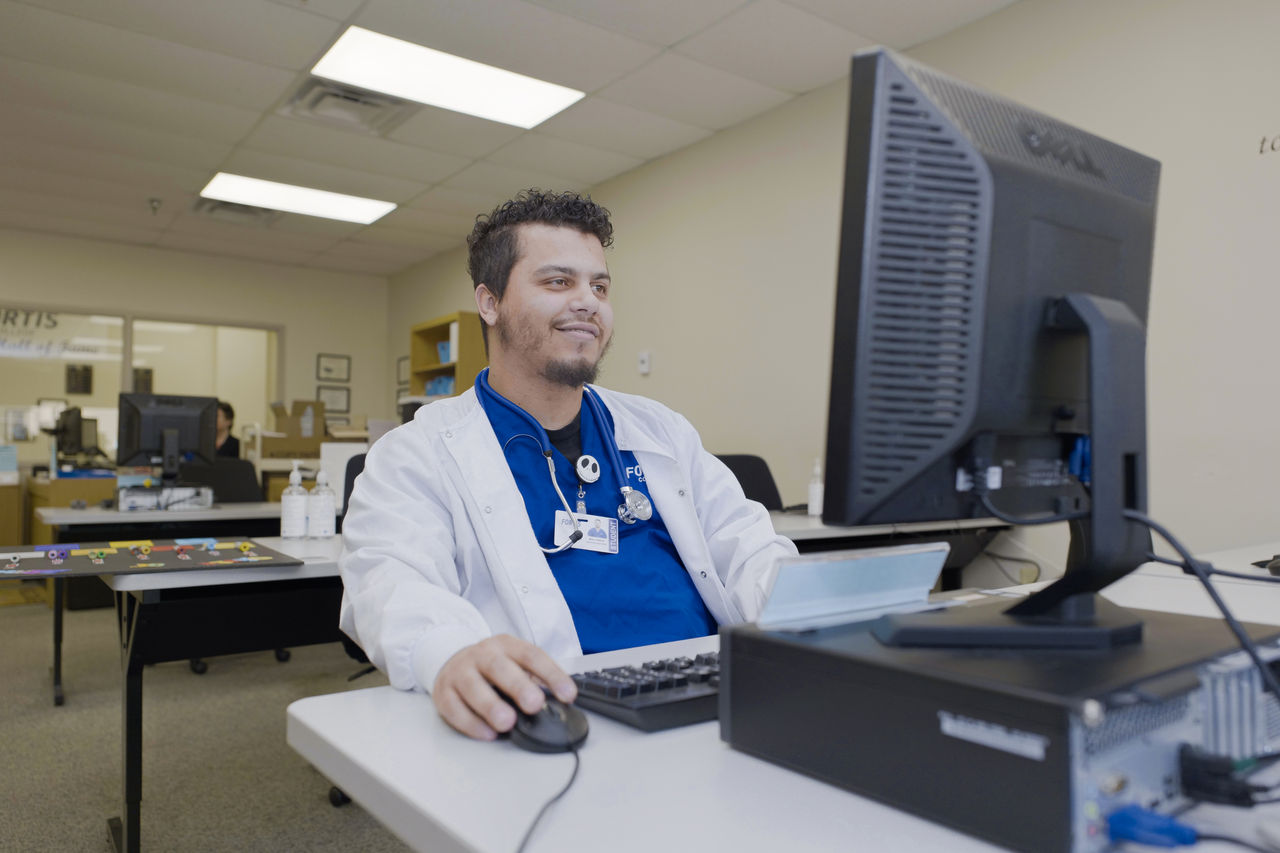 Healthcare professional working at desktop computer in office