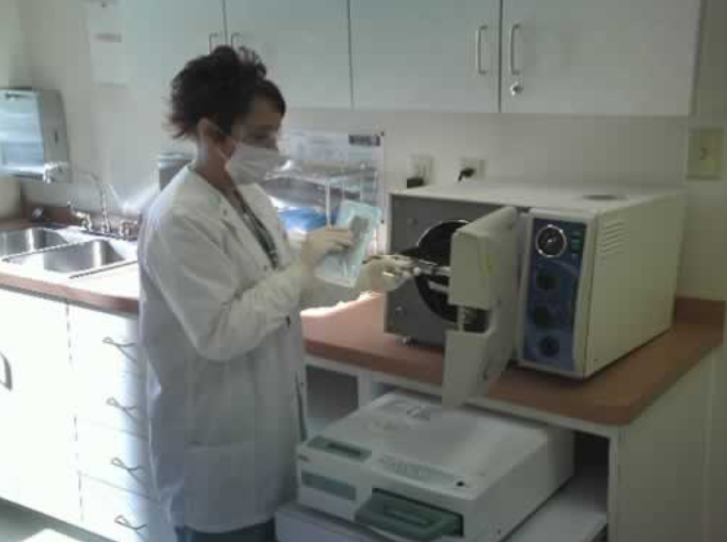 Lab technician operating sterilization equipment